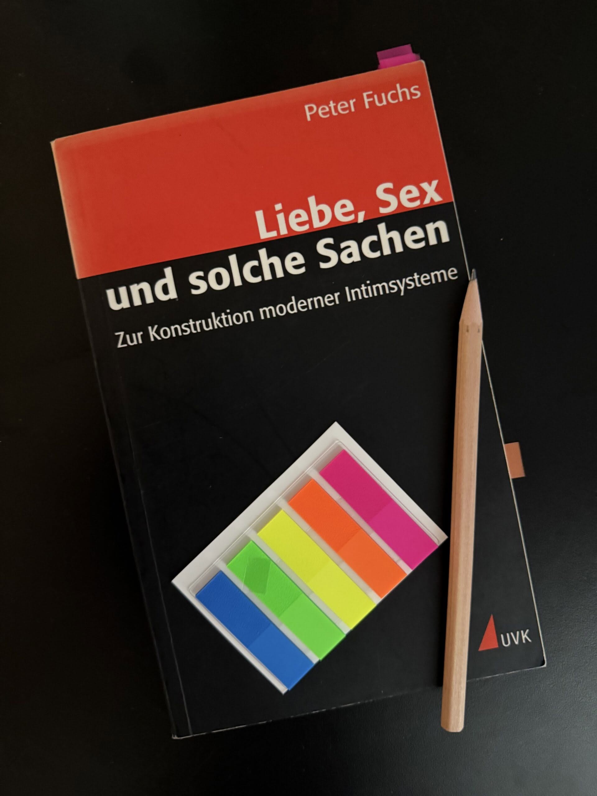 Cover Fuchs_Liebe_Sex_2 Das Buch "Fuchs, Peter (1999): Liebe, Sex und solche Sachen: Zur Konstruktion moderner Intimsysteme." auf schwarzem Untergrund. Auf dem Buch liegen ein Bleistift und ein Briefchen bunter Markierungsklebestreifen.
