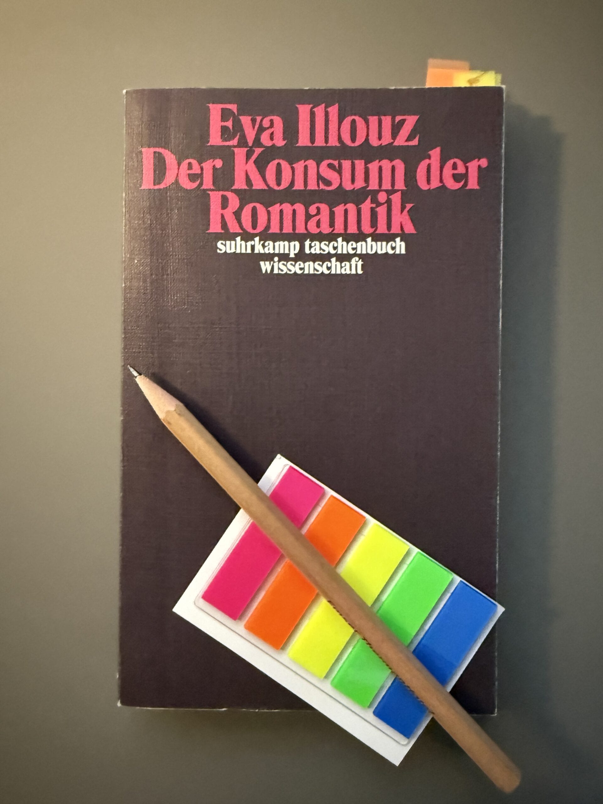 Cover Illouz_Konsum-der-romantik_2 Das Buch "Illouz, Eva (2007): Der Konsum der Romantik." auf gruaem Untergrund. Auf dem Buch liegen ein Bleistift und ein Briefchen bunter Markierungsklebestreifen.